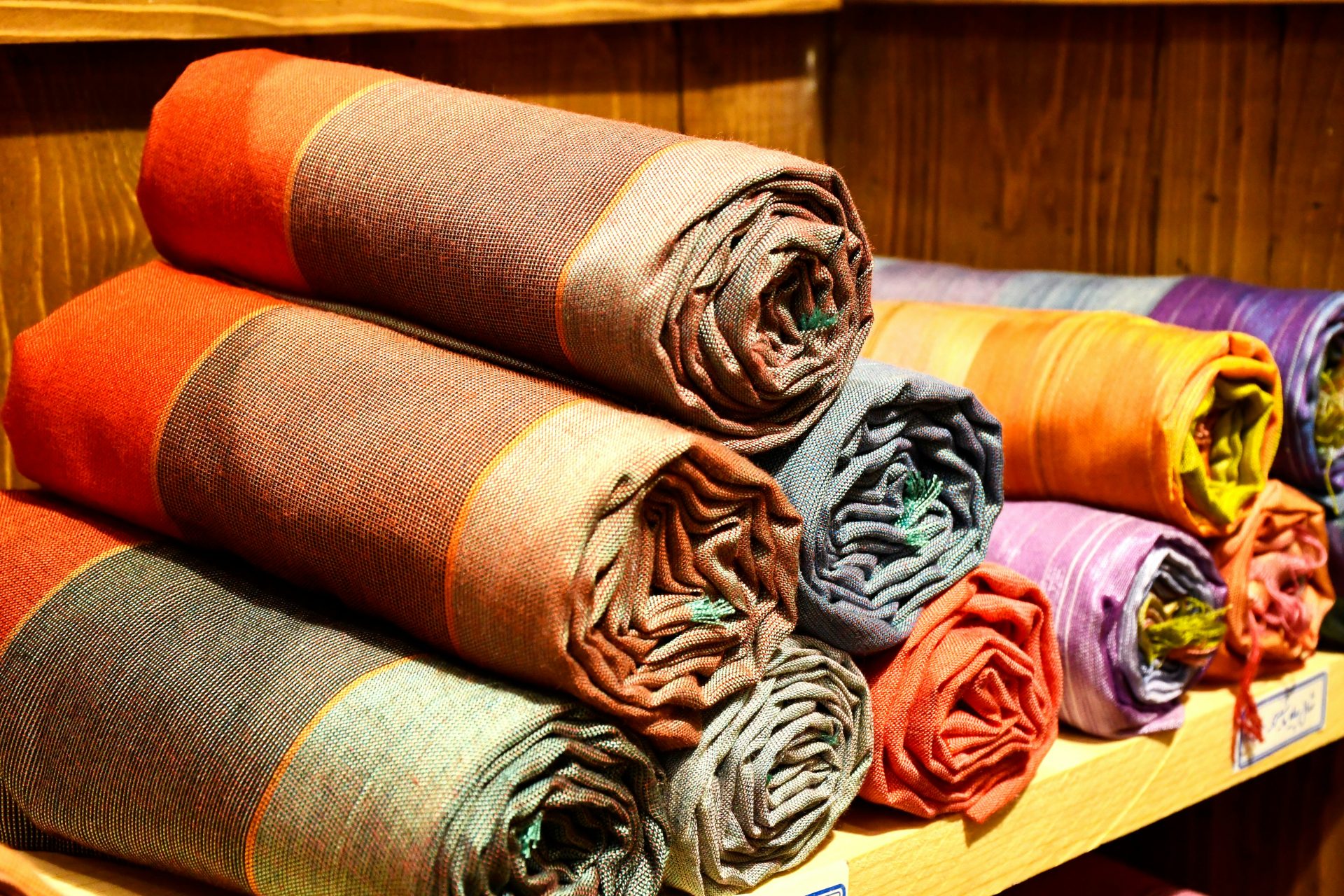 un tas de tissus de différentes couleurs sur une étagère